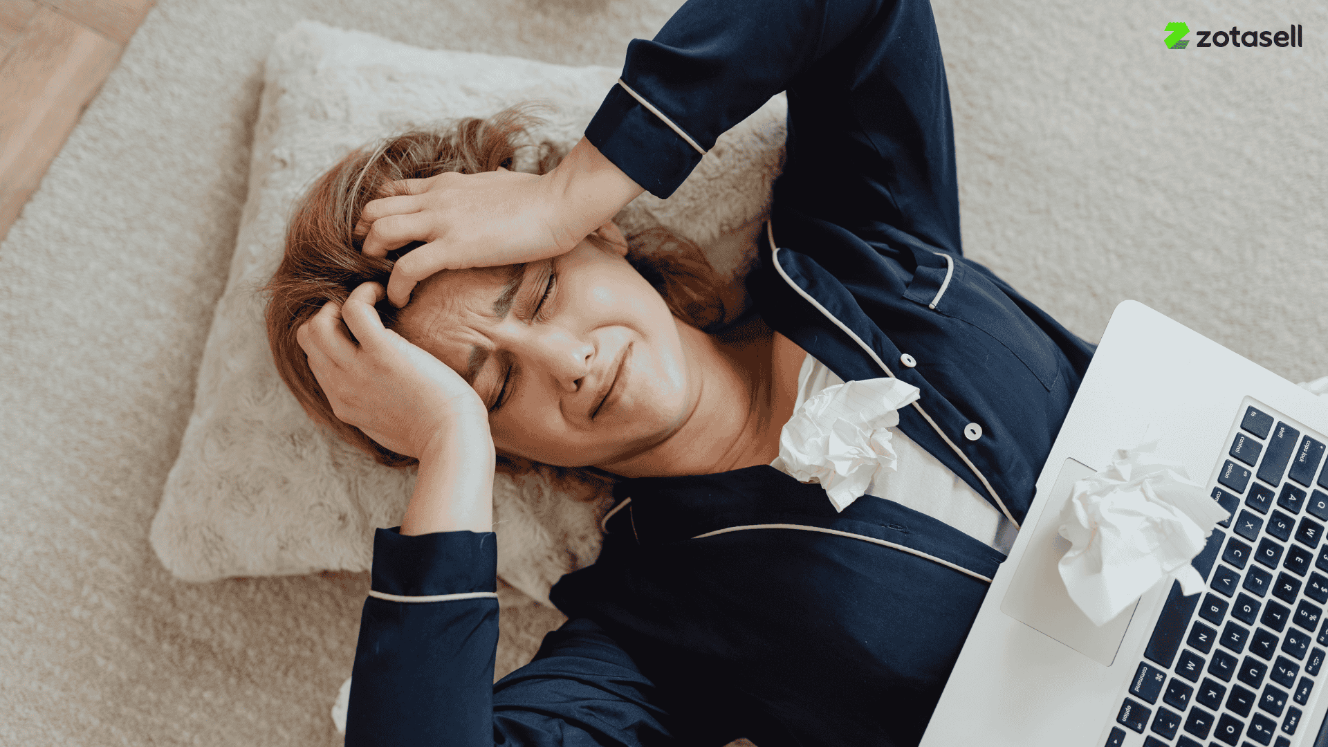 Frustrated woman holding her head while working on laptop, showing stress from handling upsells manually